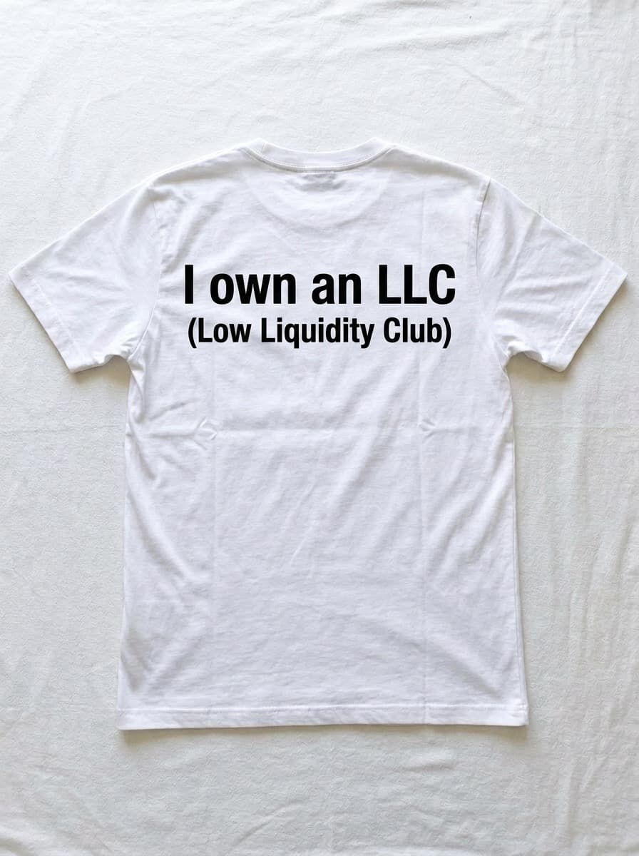 Back of a white t-shirt printed with I own an LLC in heavy black type, with Low Liquidity Club in brackets underneath.