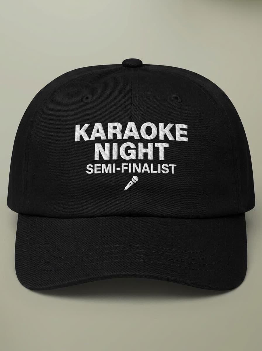 Black dad hat embroidered in white with KARAOKE NIGHT above SEMI-FINALIST and a small microphone.